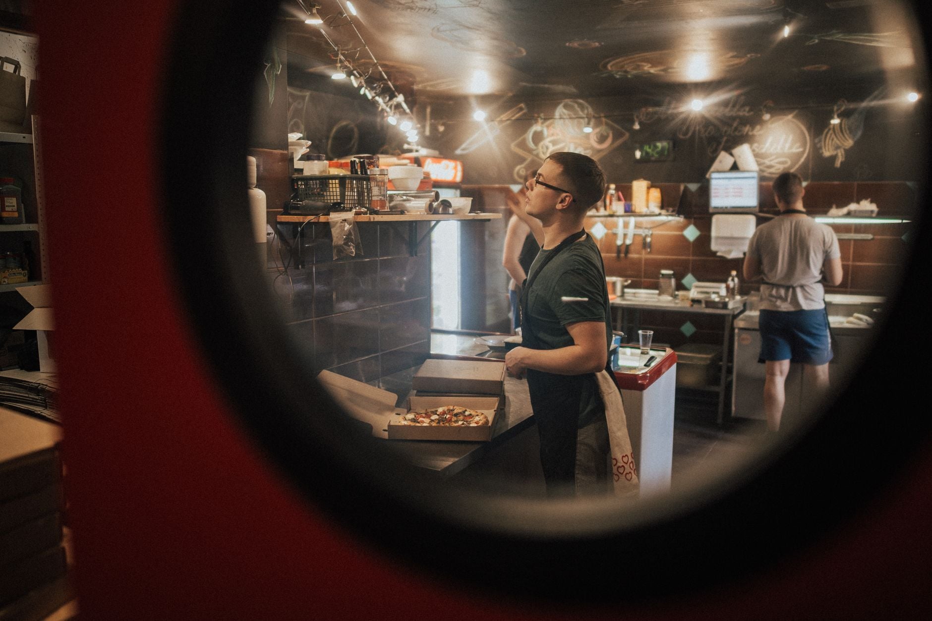 Chefs preparing pizza in a bustling restaurant kitchen. Photo by Max Avans on Pexels