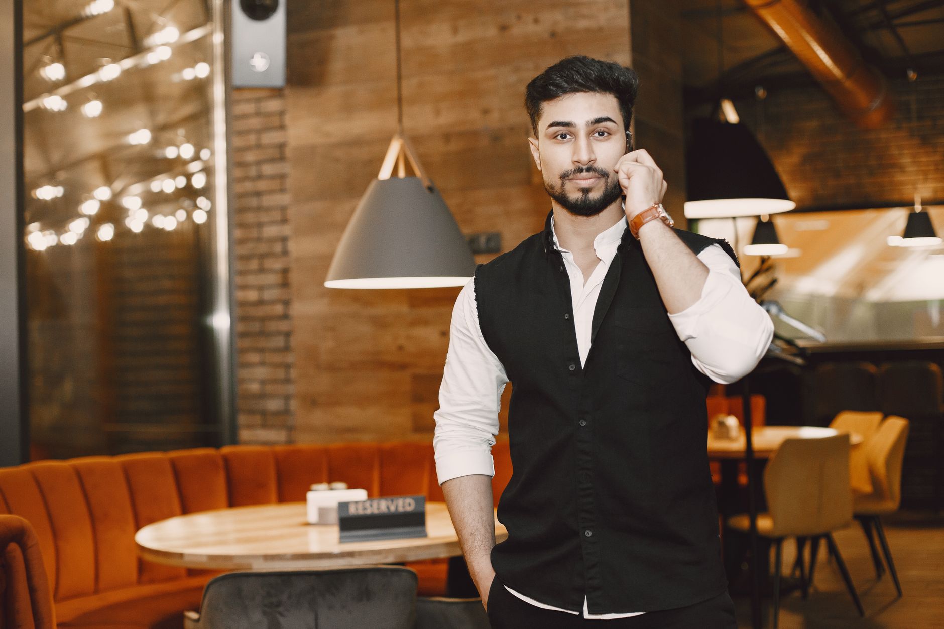 A restaurant manager on his phone inside a modern restaurant — illustrating after-hours calls and next-day pre-orders. Photo by Gustavo Fring on Pexels.